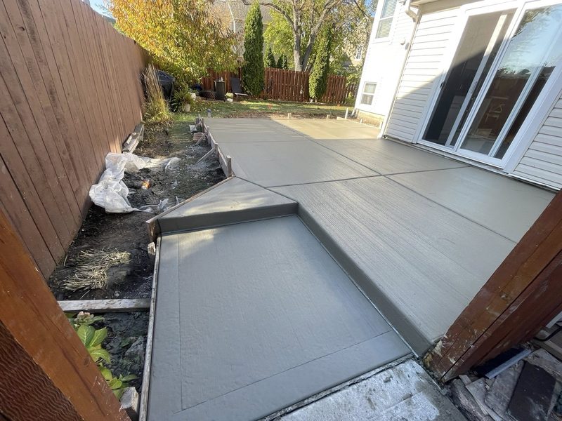 Stepped backyard concrete patio with smooth gray finish